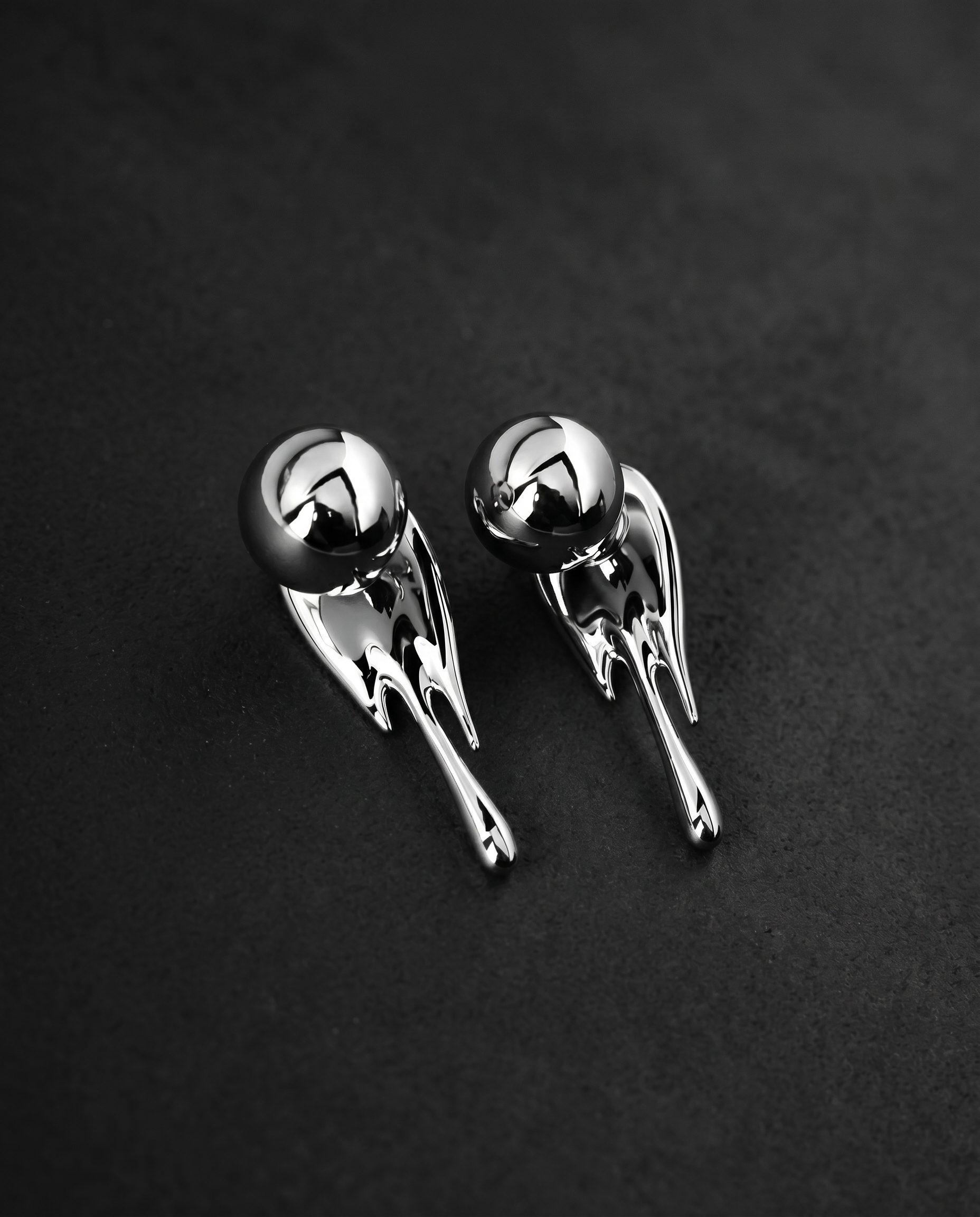 Pair of mirror-polished molten metal drop earrings in silver and gold