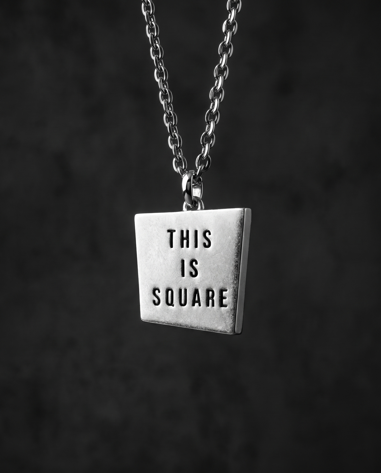 Matte silver square pendant engraved with THIS IS SQUARE on a chain