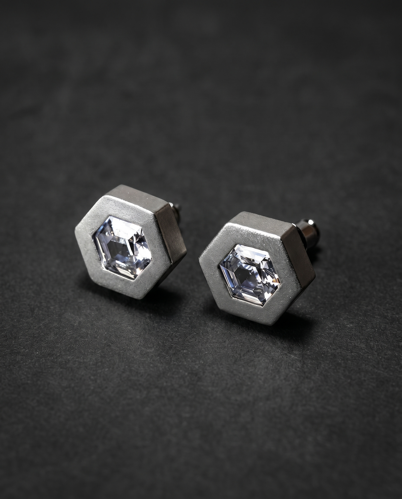 Pair of hexagonal matte silver stud earrings with clear crystals