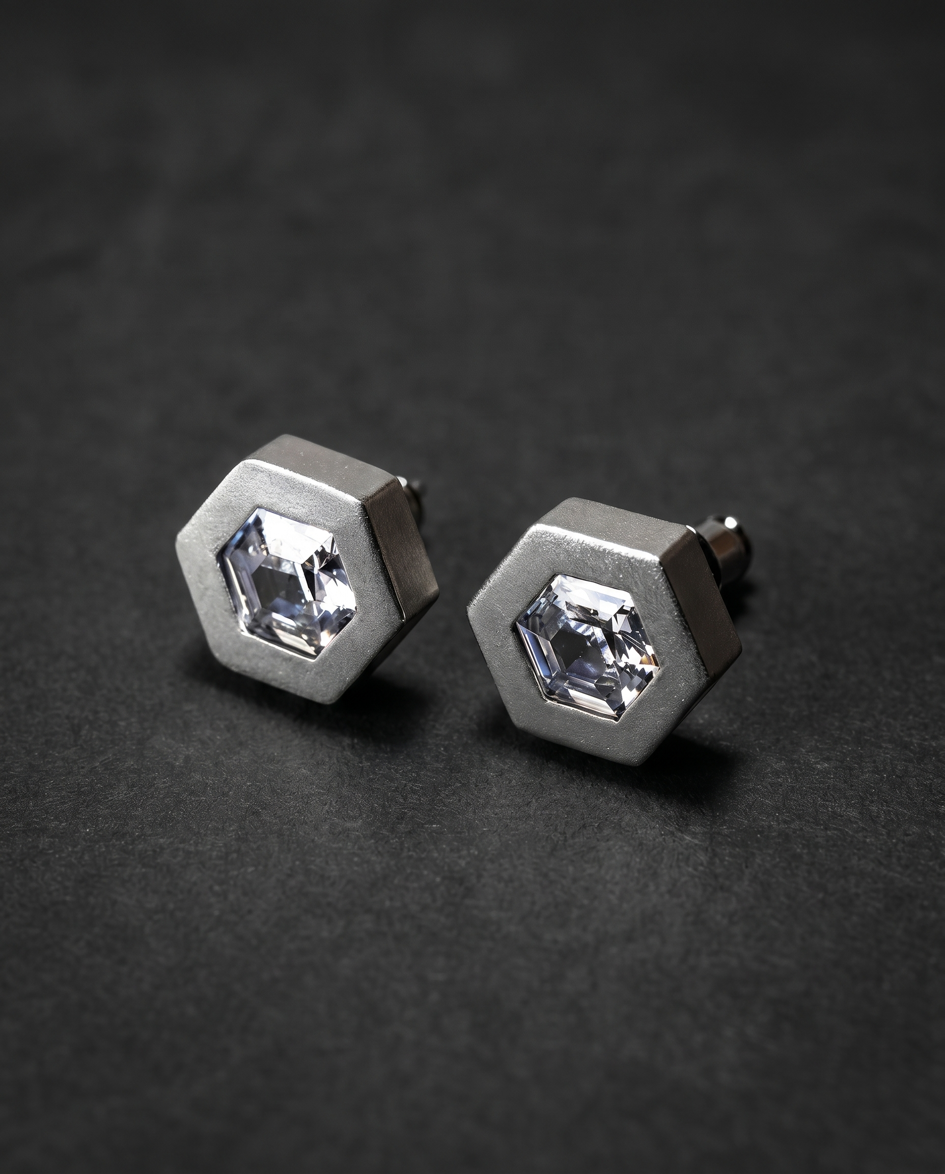 Pair of hexagonal matte silver stud earrings with clear crystals